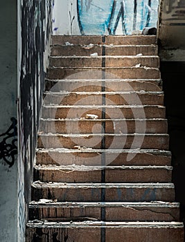 The old cement staircase and the graffiti patterns on cement wall is in the abandoned building and was left to deteriorate over
