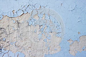 Old cement wall with peeled blue paint shabby weathered grunge wallpaper or background