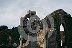 Old Cemetery in Ireland with Celtic Cross Gravestones and Old Church in Background