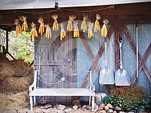 Old chair, gardening tools in front of barn