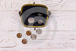 Old change purse with several coins on white wooden background. Concept of poverty or bankruptcy