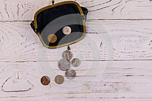 Old change purse with several coins on white wooden background. Concept of poverty or bankruptcy