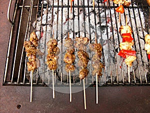 Old charcoal grill with delicious poultry skewers and peppers as well as mushrooms at a barbecue
