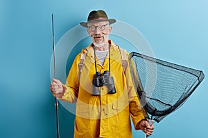 Old cheerful man spending his holiday on fishing