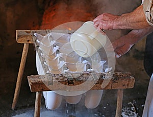 old cheesemaker during the preparation of the cheese in the chee