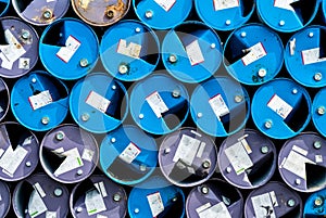 Old chemical barrels. Blue and purple oil drum. Steel oil tank. Toxic waste warehouse. Hazard chemical barrel with warning label.