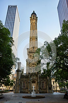 Old Chicago water tower with historic architecture and water fountain and trees in front of building