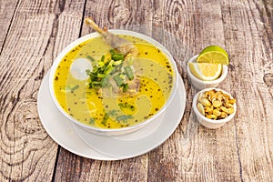 Old chicken broth with typical Peruvian recipe accompanied by a bit of cancha and slices of lime and lemon photo
