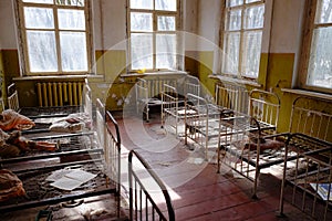 Old children`s beds in an abandoned kindergarten. The interior of a room in one of the buildings in the Chernobyl radioactive