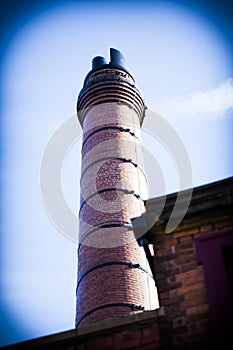 An old chimney at an old red brick factory. Industrial concept image with old factories with chimney.