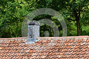 Old chimney on a tiled cottage roof