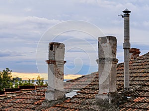 Old chimneys on the tiled roof of an ancient building