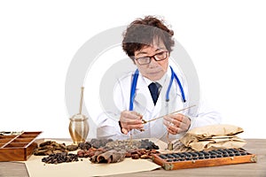 An old Chinese doctor is preparing herbs in front of a white background