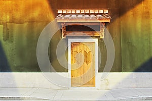 An old chinese door in a illuminating wall photo