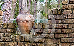 Old chipped roman vase on a brick wall, outdoor garden decorations and architecture