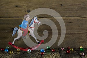 Old christmas decoration of tin: rocking horse on wooden background.