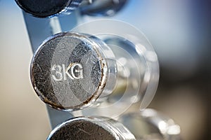 Old chrome 3kg dumbbell in a rack.