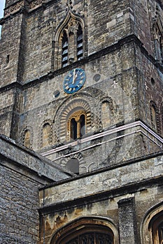 Church clock tower with blue clock face in the classic style in England