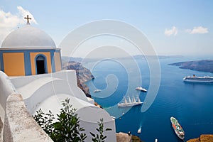 Old church dome and view of boats in Santorini