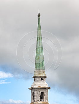 Old church spire against cloudy sky