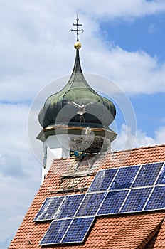 Old church tower and storks nesting in Germany