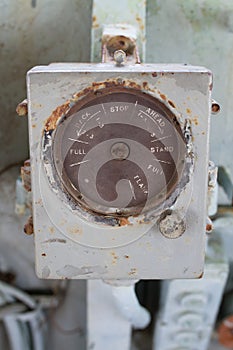 Old circle meter display in gray metal box.