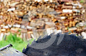 Old circular saw blade and wood logs background