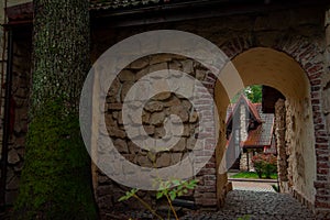 Old city back street landmark urban view cable stone road arch path way and small cozy houses with shingle roofs