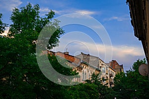 Old city building of country in Eastern Europe, green town street in summer clear day