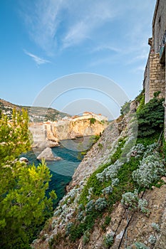 Old city Dubrovnik panorama. View of town roofs, cliff above the sea and small harbor with boats