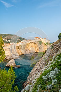 Old city Dubrovnik panorama. View of town roofs, cliff above the sea and small harbor with boats