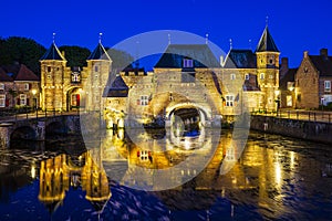 Old city gate Koppelpoort in Amersfoort city, the Netherlands during sunset. Two towers are connected to an arch gate