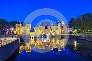 Old city gate Koppelpoort in Amersfoort city, the Netherlands during sunset. Two towers are connected to an arch gate