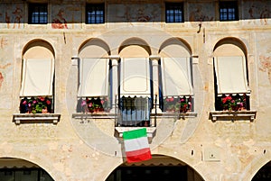 Old City Hall with flowers in Oderzo in the province of Treviso in the Veneto (Italy)