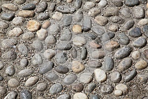Old city pavement made of pebbles. Milan, Northern Italy, Europe