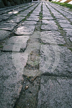 Old city road paved with granite gray stone. texture old stone pavement in the city