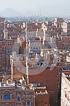 The Old City of Sana'a, decorated houses, palace, minarets and the Saleh Mosque in the fog, Yemen