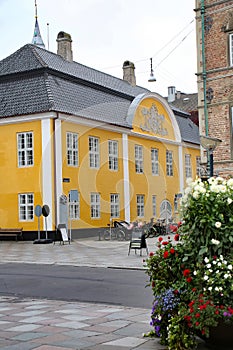 Old City Town Hall. Beautiful historic yellow and white painted building in the city center, Aalborg, Denmark.