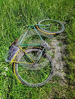 old classic bike abandoned on the grass during the daytime in summer.