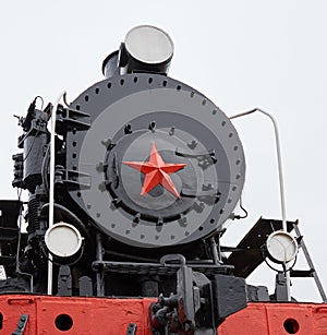 Old classic black soviet steam locomotive with red star on front, close up view on star