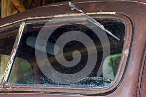 A old classic car with dirty glass and broken windshield, detail of old car