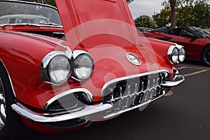 an old, classic, convertible style red corvette car with its hood up