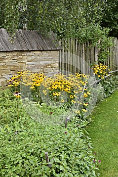 An old classic European wooden house complete with a yard, a classic country garden and a shed