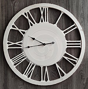 Old classic fashioned clock with Roman Numeral on wooden backgounds