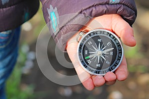 Old classic navigation compass in childs hand