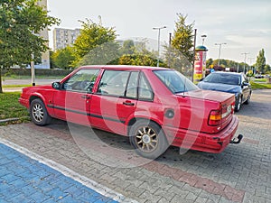 Old classic red Swedish sedan car Volvo 940 parked
