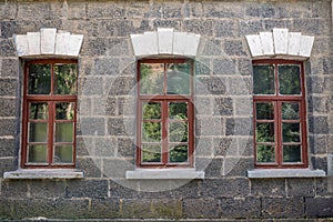 An old classic stone house with windows. Calssic stone walls and windows textures.