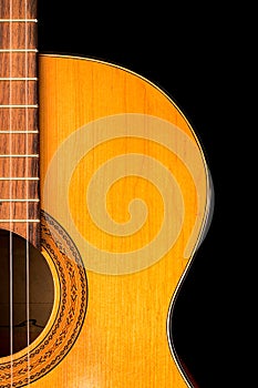 The old classical guitar on black background.