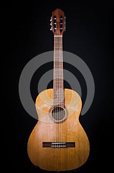 Old classical guitar on a black background photo
