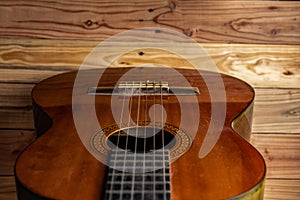 Old classical guitar on wooden background